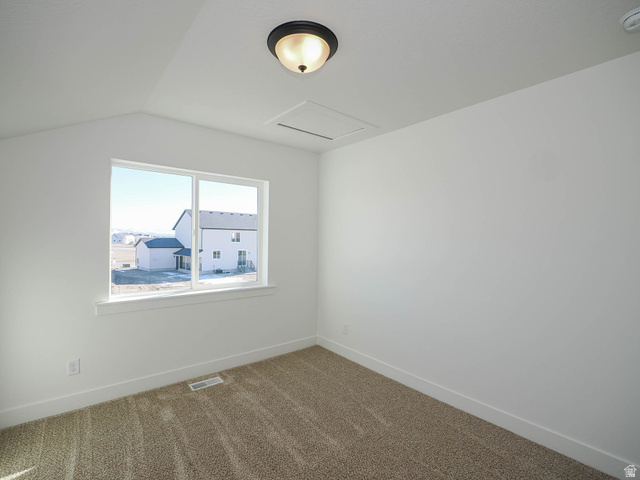 3938 North Wood Road Eagle Mountain, UT 84005 - Photo 37 of 55 Unfurnished room with dark carpet, vaulted ceiling, and a smoke detector