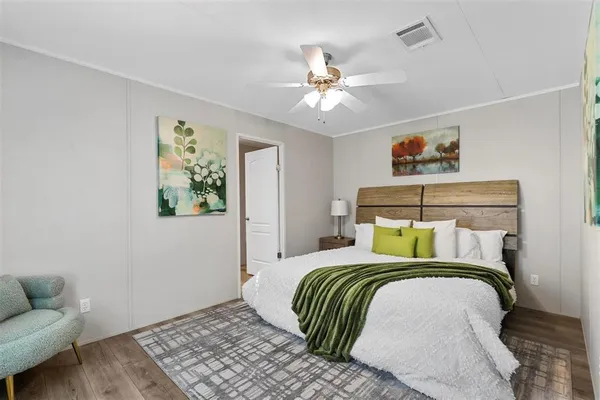 a bedroom with a bed and painting on the wall