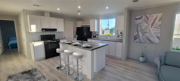 a kitchen with stainless steel appliances kitchen island granite countertop a stove a sink a refrigerator and a microwave