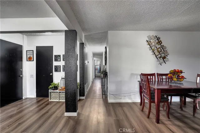 a view of a hallway to a livingroom with furniture and wooden floor