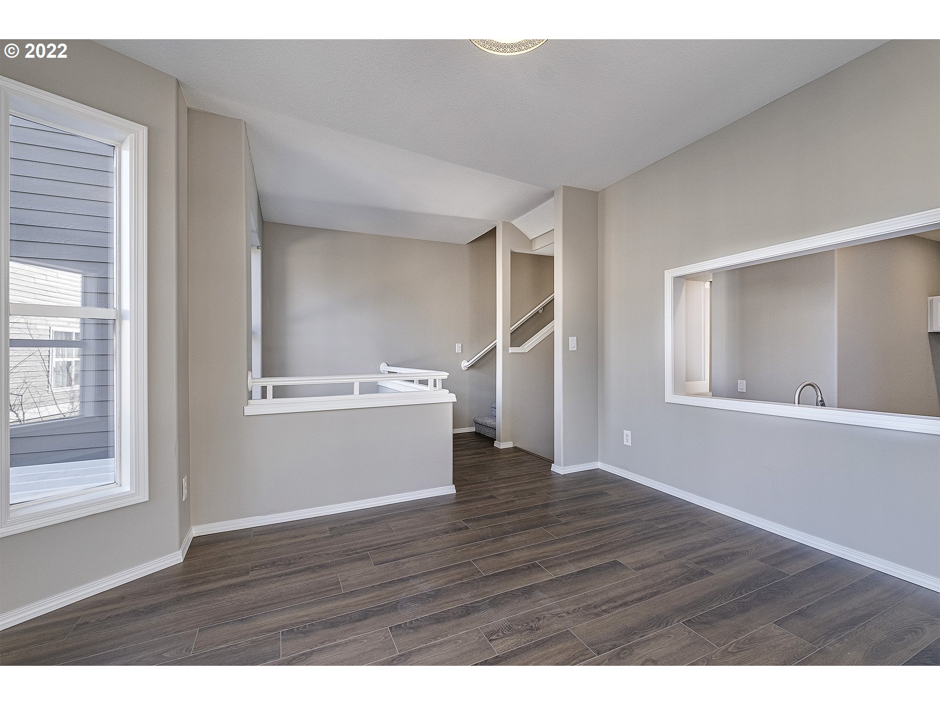 15718 Southwest Flagstone Drive Beaverton, OR 97007 - Photo 12 of 32 a view of an empty room with wooden floor and a window