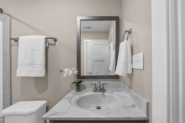 a bathroom with a sink toilet and mirror