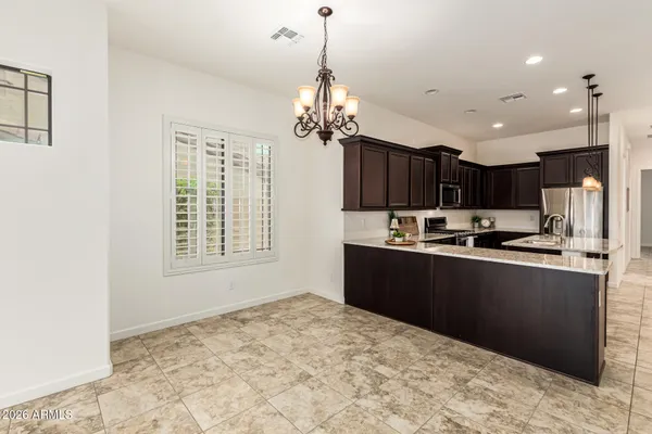 a kitchen with stainless steel appliances granite countertop a sink a stove a refrigerator and a refrigerator