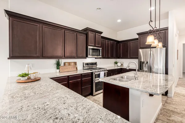 a kitchen with stainless steel appliances granite countertop a sink stove and cabinets
