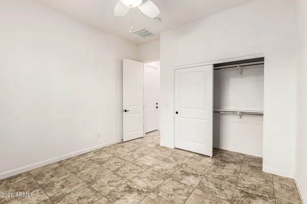 a view of yellow house with flower garden in front of main door