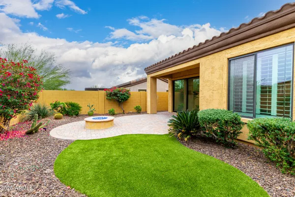 a living room with patio furniture and floor to ceiling windows