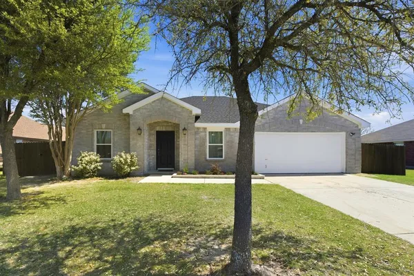 a front view of a house with yard and green space