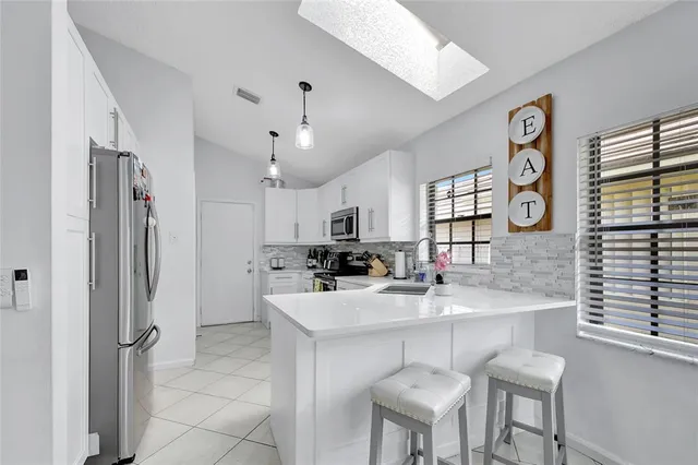 a kitchen with stainless steel appliances granite countertop a sink refrigerator and cabinets