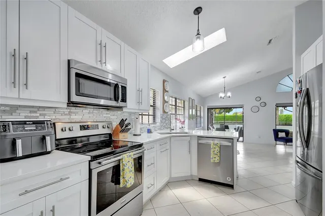 a kitchen with stainless steel appliances granite countertop a sink a stove top oven a counter space and cabinets