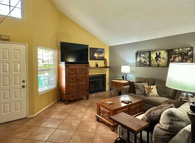 a living room with furniture a flat screen tv and a fireplace