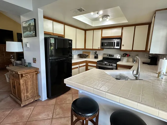 a kitchen with stainless steel appliances granite countertop a sink refrigerator stove and microwave