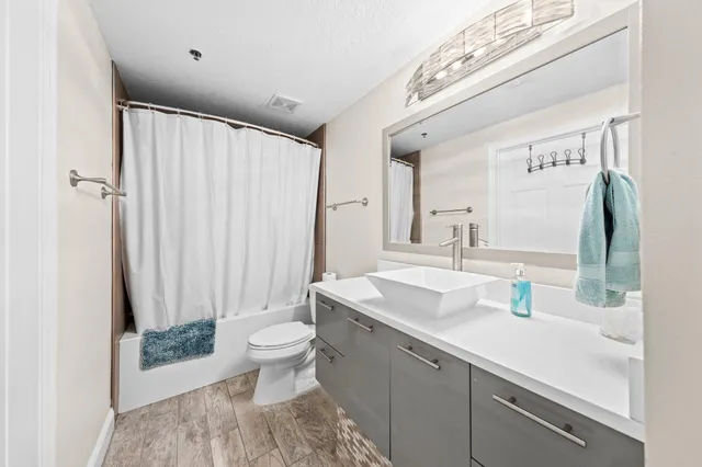 a bathroom with a sink a toilet and shower