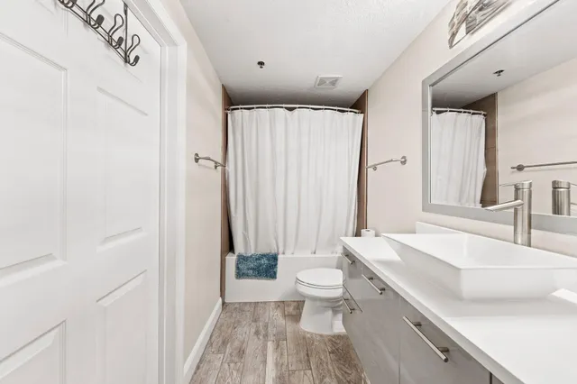 a bathroom with a sink a toilet and a large mirror