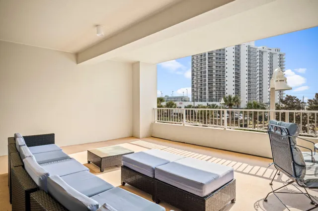 a living room with furniture a large window and wooden floor