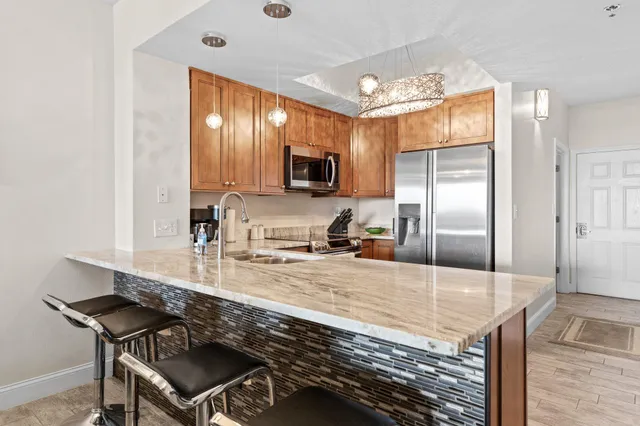 a kitchen with kitchen island granite countertop a stove cabinets and refrigerator