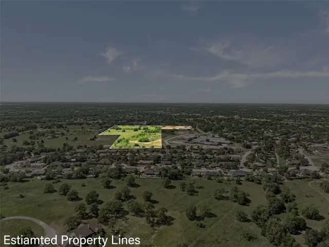 an aerial view of residential houses with outdoor space and trees
