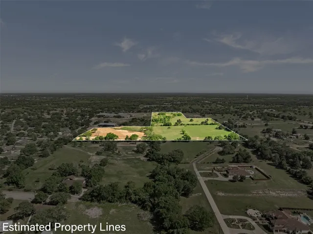 an aerial view of residential houses with outdoor space and trees