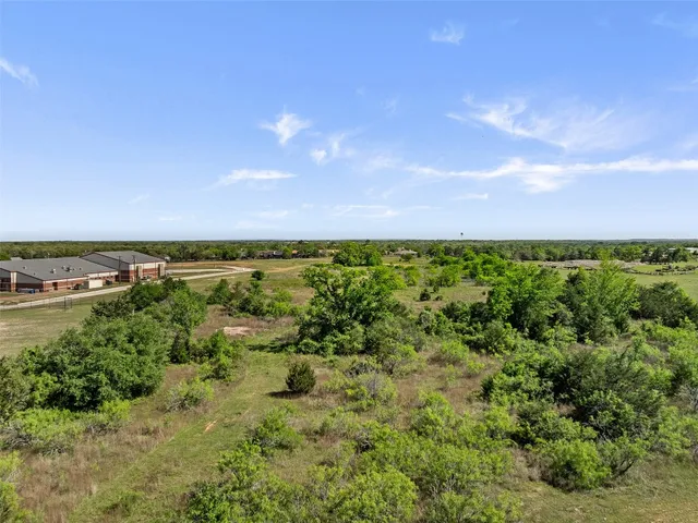 a view of a green field with lots of bushes