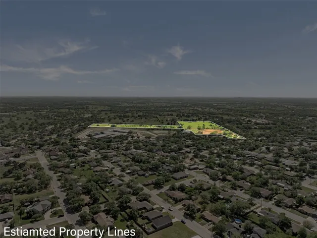 an aerial view of residential houses with outdoor space and trees
