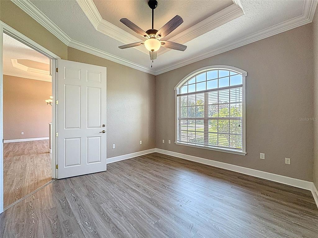 11235 Warm Wind Way Weeki Wachee, FL 34613 - Photo 14 of 93 an empty room with wooden floor chandelier fan and windows