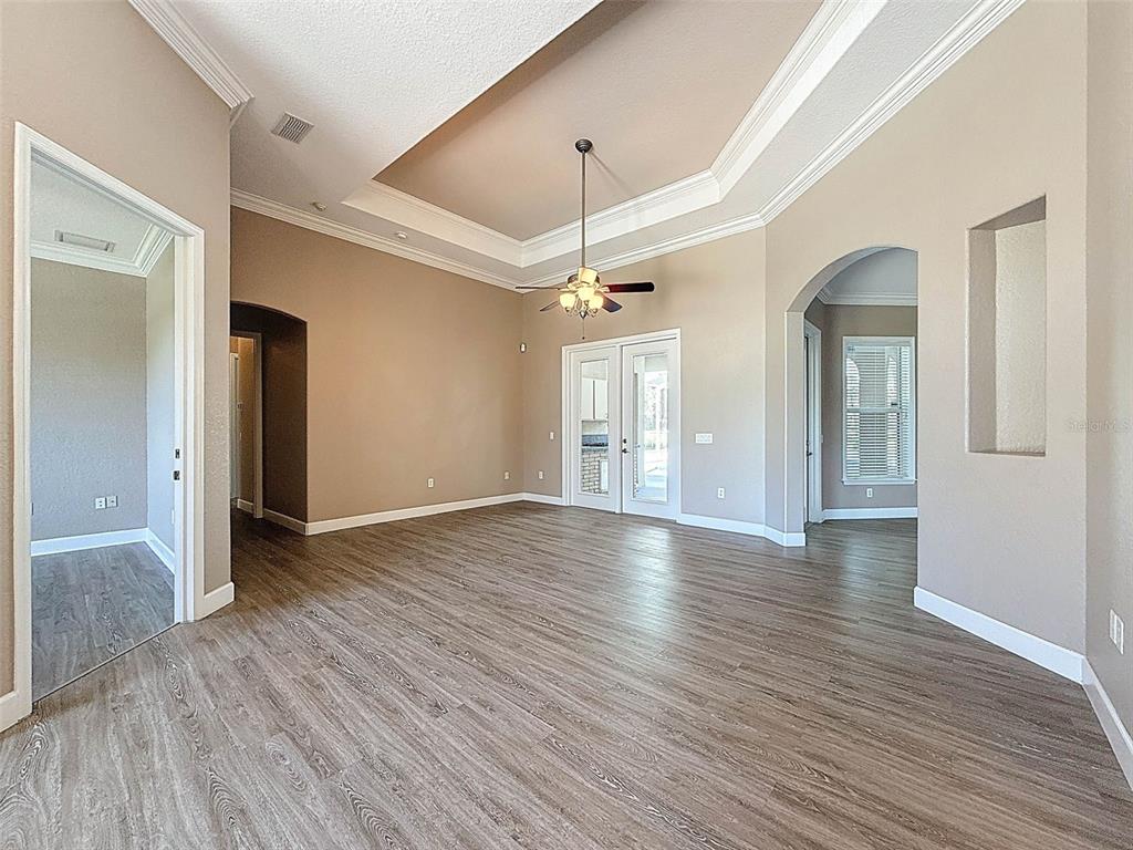 11235 Warm Wind Way Weeki Wachee, FL 34613 - Photo 17 of 93 a view of an empty room with wooden floor and a window