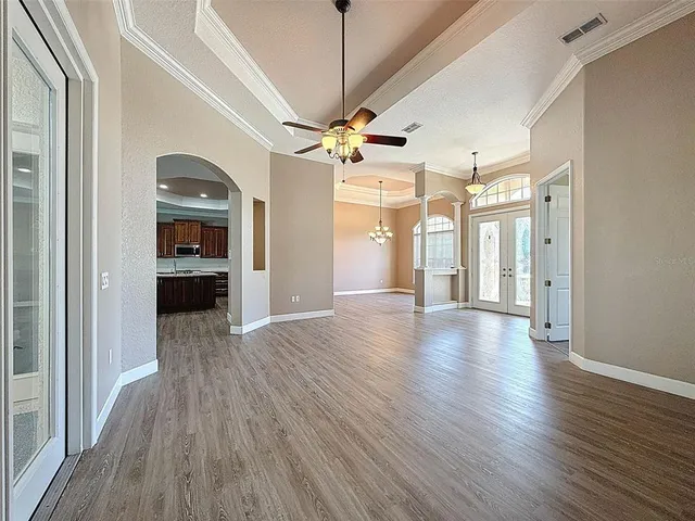 a view of a livingroom with a ceiling fan window and wooden floor