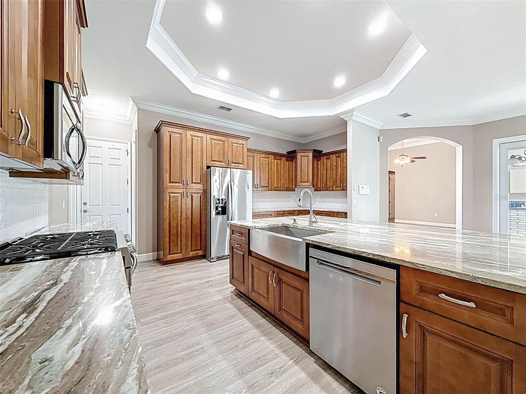 11235 Warm Wind Way Weeki Wachee, FL 34613 - Photo 23 of 93 a large kitchen with stainless steel appliances granite countertop a lot of counter space and wooden floor