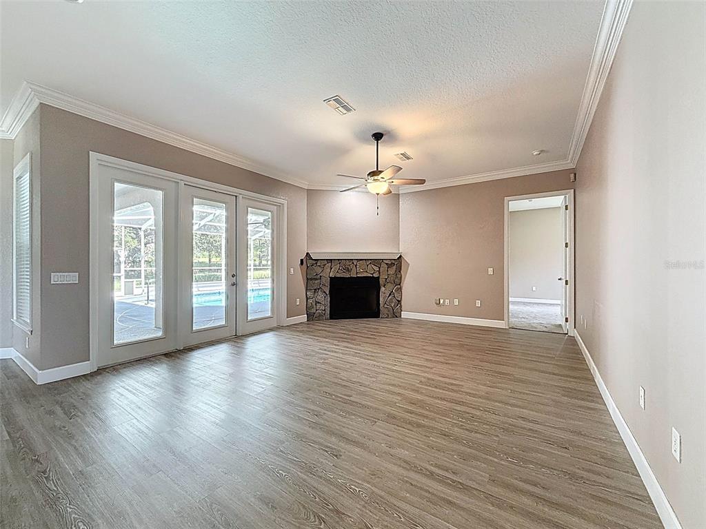 11235 Warm Wind Way Weeki Wachee, FL 34613 - Photo 30 of 93 a view of a livingroom with a fireplace wooden floor and chandelier