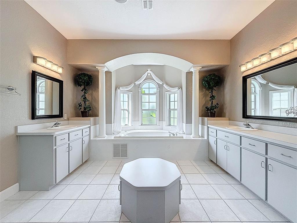 11235 Warm Wind Way Weeki Wachee, FL 34613 - Photo 38 of 93 a large bathroom with a granite countertop sink mirror and a bathtub with vanity