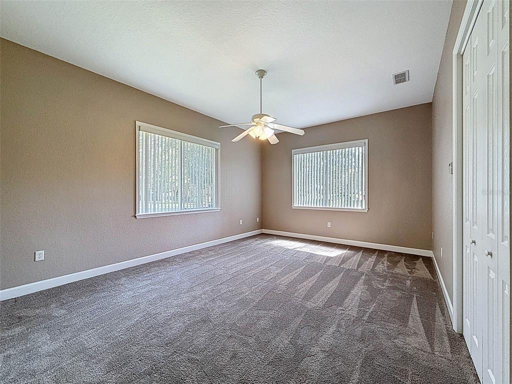 11235 Warm Wind Way Weeki Wachee, FL 34613 - Photo 56 of 93 an empty room with windows and chandelier fan