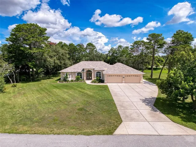 a view of an empty room with wooden floor and fan
