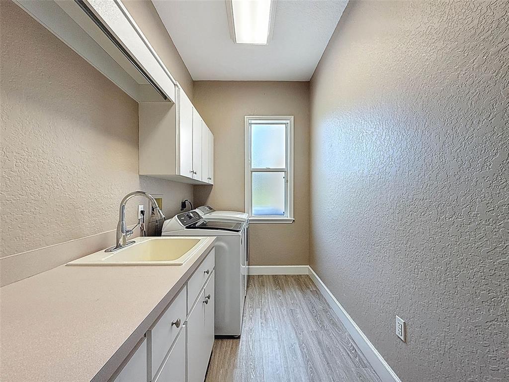 11235 Warm Wind Way Weeki Wachee, FL 34613 - Photo 72 of 93 a room with a sink a window and wooden floor