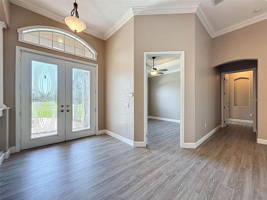 11235 Warm Wind Way Weeki Wachee, FL 34613 - Photo 9 of 93 a view of a hallway with wooden floor and a chandelier