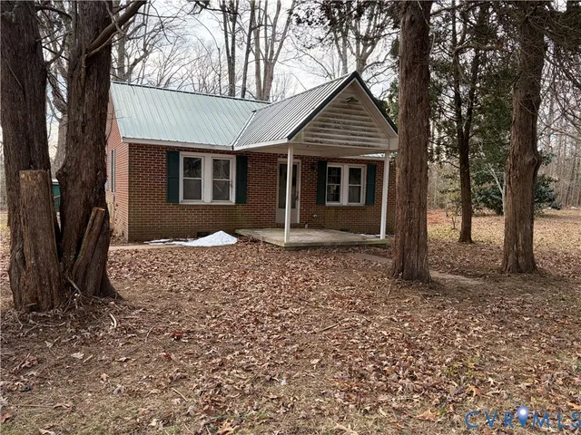 a front view of a house with a yard and tree
