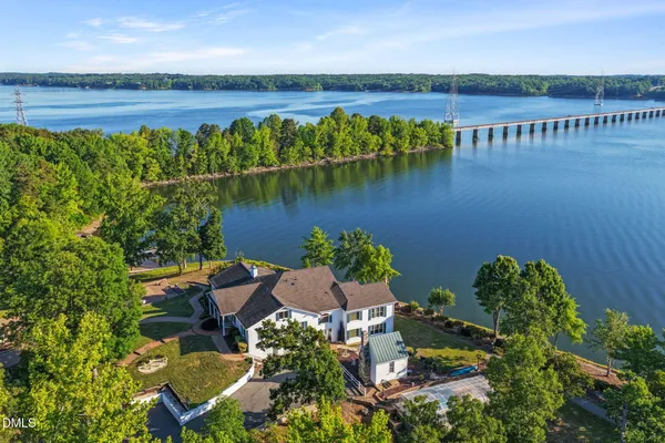 an aerial view of a house with a yard and a large tree