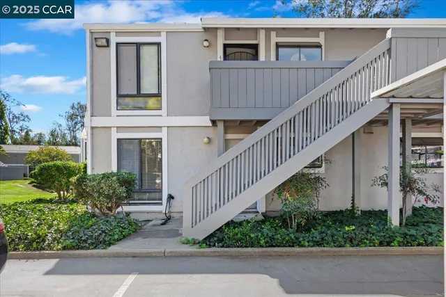 a view of a house with wooden stairs and a small yard