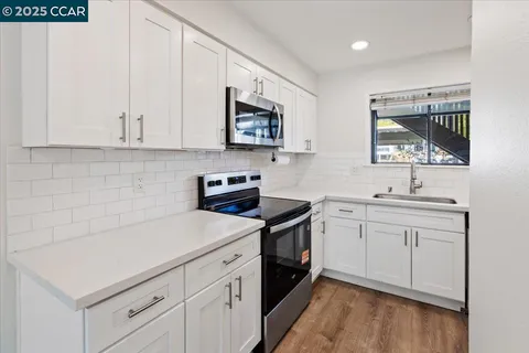 a kitchen with a sink stove and microwave