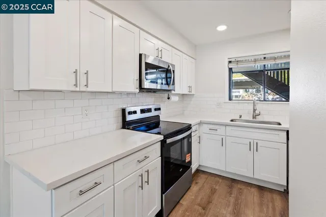 a kitchen with a sink stove and microwave