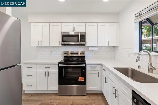 a kitchen with stainless steel appliances a stove a microwave and cabinets
