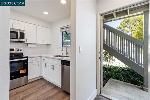 a kitchen with stainless steel appliances a dining table and chairs