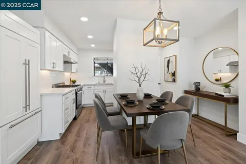 a kitchen with white cabinets and wooden floor