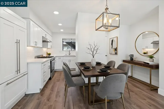 a kitchen with white cabinets and wooden floor
