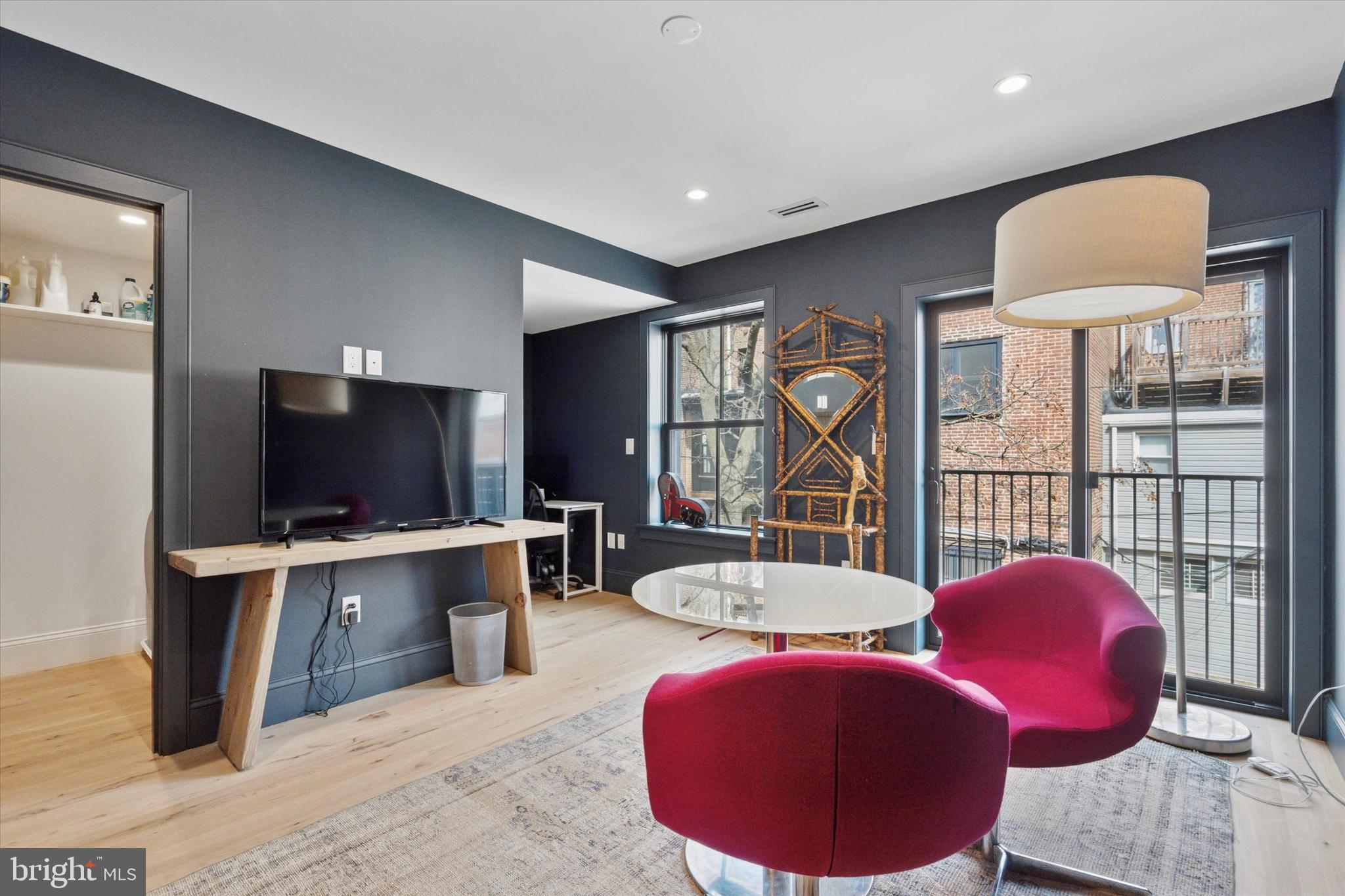 1725-27 Addison Street Philadelphia, PA 19146 - Photo 23 of 43 a living room with furniture a flat screen tv and a floor to ceiling window