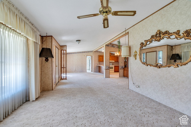12958 South 300 East Draper, UT 84020 - Photo 36 of 38 Spare room with crown molding, carpet floors, ceiling fan, and wallpapered walls