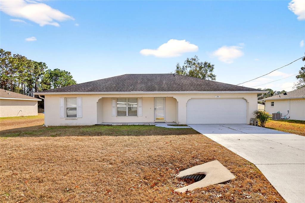 24 Pecan Pass Run Ocala, FL 34472 - Photo 1 of 1 a front view of a house with a yard and garage