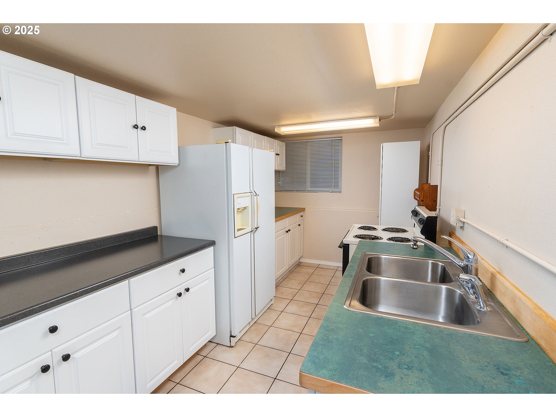 12444 Southwest Green Drive Culver, OR 97734 - Photo 17 of 34 a kitchen with granite countertop a sink a refrigerator a stove and white cabinets