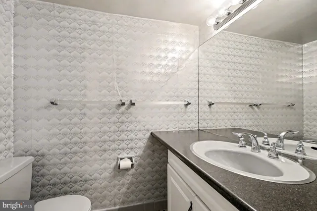 a bathroom with a sink toilet and a mirror