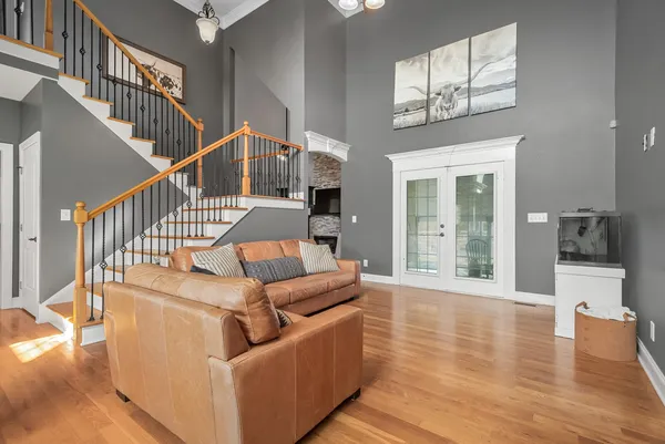a living room with furniture chandelier and a window