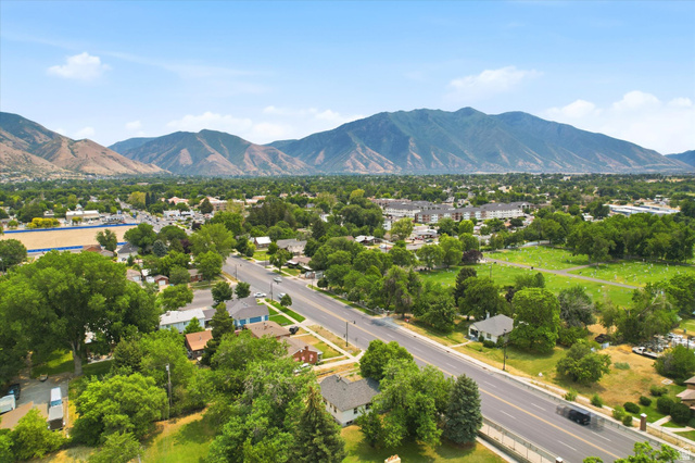 262 West 400 South Springville, UT 84663 - Photo 7 of 17 Expansive mountain range backdrop framing a residential area with mature trees and a wide thoroughfare