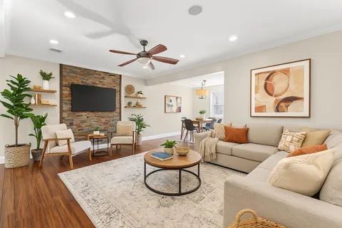 a living room with furniture a rug and a flat screen tv